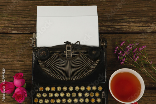 Typewriter, flowers and lemon tea on table