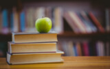 Green apple on stack of books