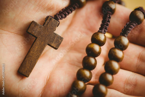 Hand holding rosary beads
