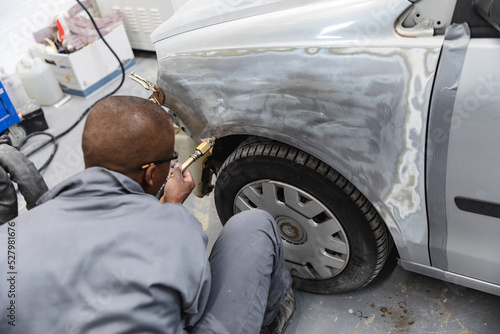 African American mechanic man working on a car photo