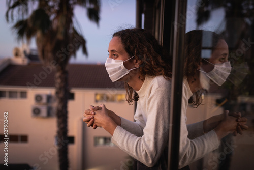 Woman wearing a face mask at home. Social distancing in quarantine during coronavirus epidemic photo