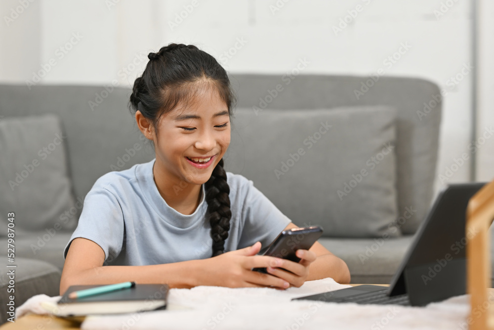 Asian little school girl using tablet and smartphone for studying online classes at home, Online learning, E-learning, Distance learning, online education concept. Asian little school girl using tablet and smartphone for studying online classes at home, Online learning, E-learning, Distance learning, online education concept.