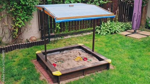 Obraz na płótnie Kids Sandbox with Blue Canopy Roof Built in Backyard Garden