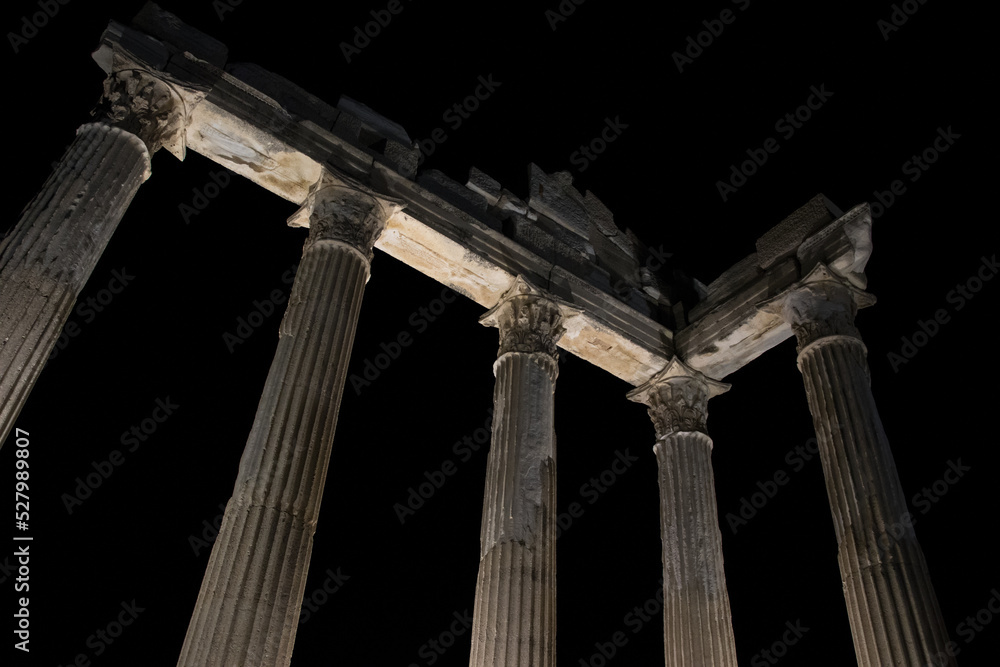 Historical building with marble columns. Elements of architectural decoration. Illuminated at night.