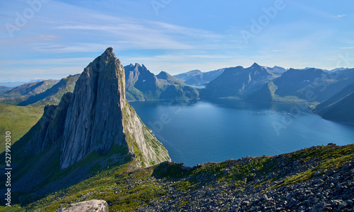 View from the mount Hesten on iconic mountain Segla in a summer sunny day. Mountain ranges at the background. Fjordgard, Senja island, Norway. Summer vacation in Lofoten   