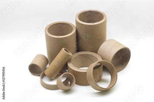 Cardboard cores of different sizes for winding various strips of material in the printing house. Industrial paper cores, tube and spools on a white background. Selective focus