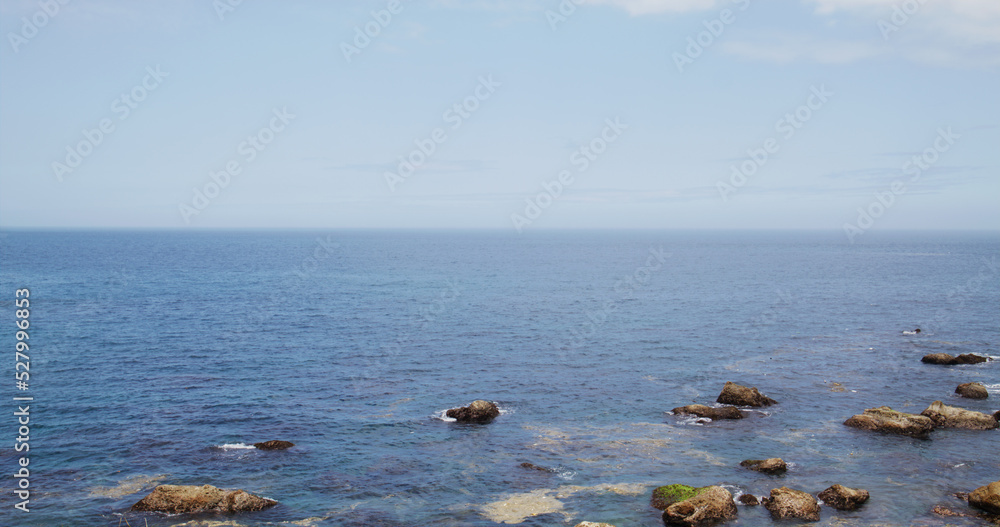 Sea water wave over the rock and stone beach