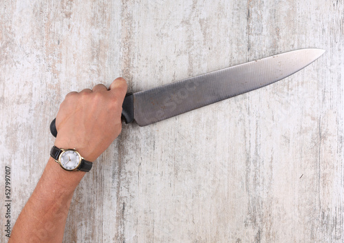 hand with a knife on the table photo