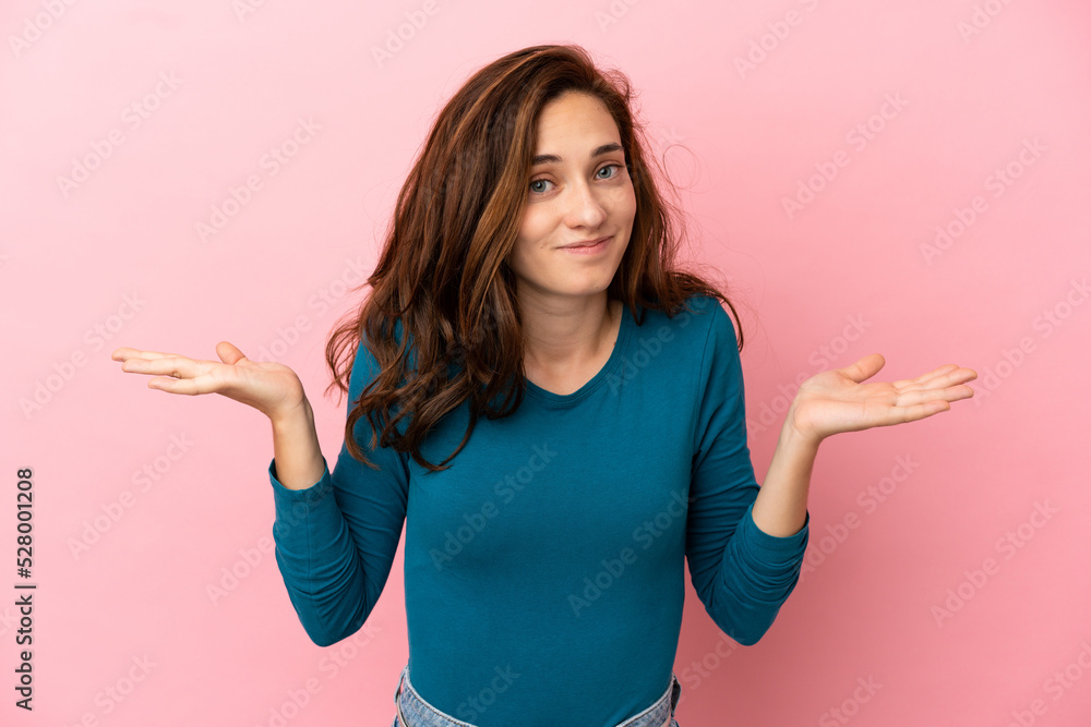 Young caucasian woman isolated on pink background having doubts while raising hands Young caucasian woman isolated on pink background having doubts while raising hands