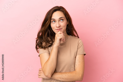 Young caucasian woman isolated on pink background thinking an idea while looking up © luismolinero