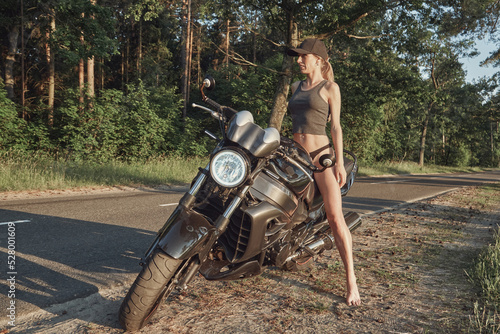 Young woman biker in a helmet sitting on a motorcycle in the underground parking garage