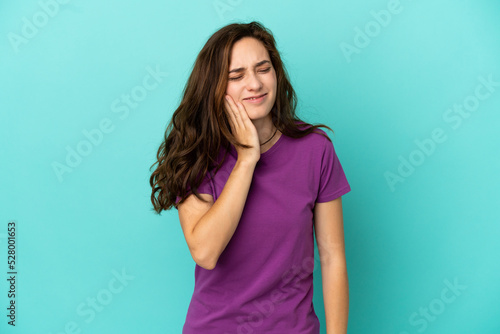 Young caucasian woman isolated on blue background with toothache