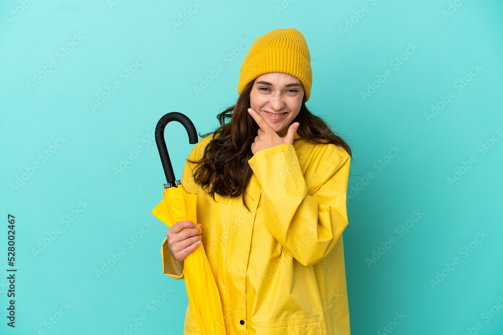 Young caucasian man holding an umbrella isolated on blue background happy and smiling Young caucasian man holding an umbrella isolated on blue background happy and smiling
