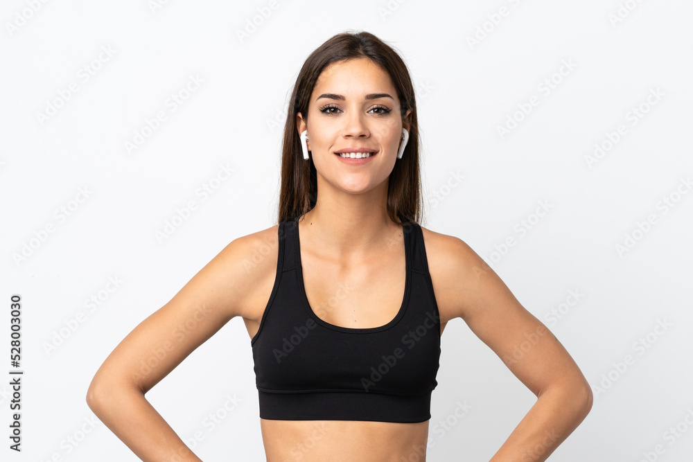 Young sport woman isolated on white background posing with arms at hip and smiling