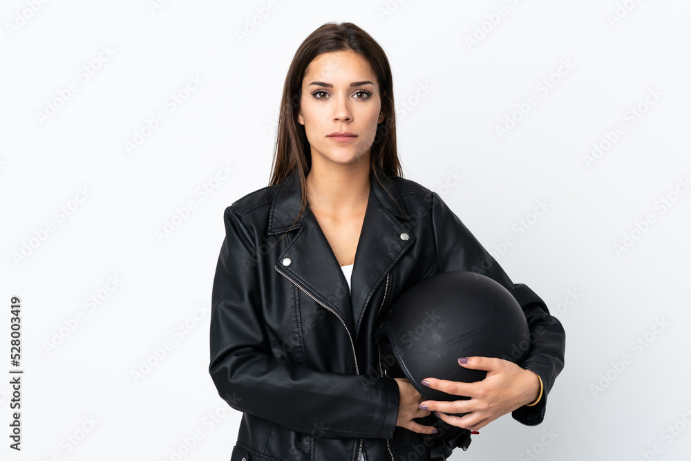 Caucasian girl holding a motorcycle helmet on white background keeping arms crossed Caucasian girl holding a motorcycle helmet on white background keeping arms crossed