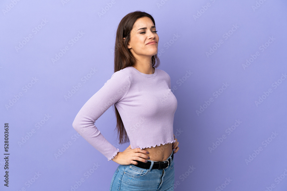 Young caucasian woman over isolated background suffering from backache for having made an effort Young caucasian woman over isolated background suffering from backache for having made an effort