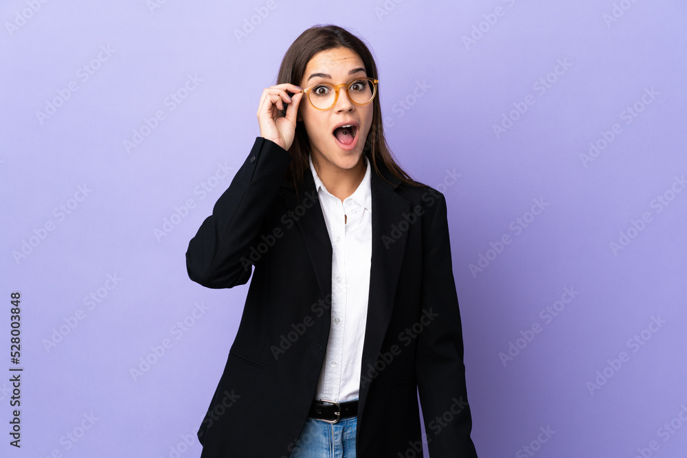 Business woman isolated on purple background with glasses and surprised Business woman isolated on purple background with glasses and surprised