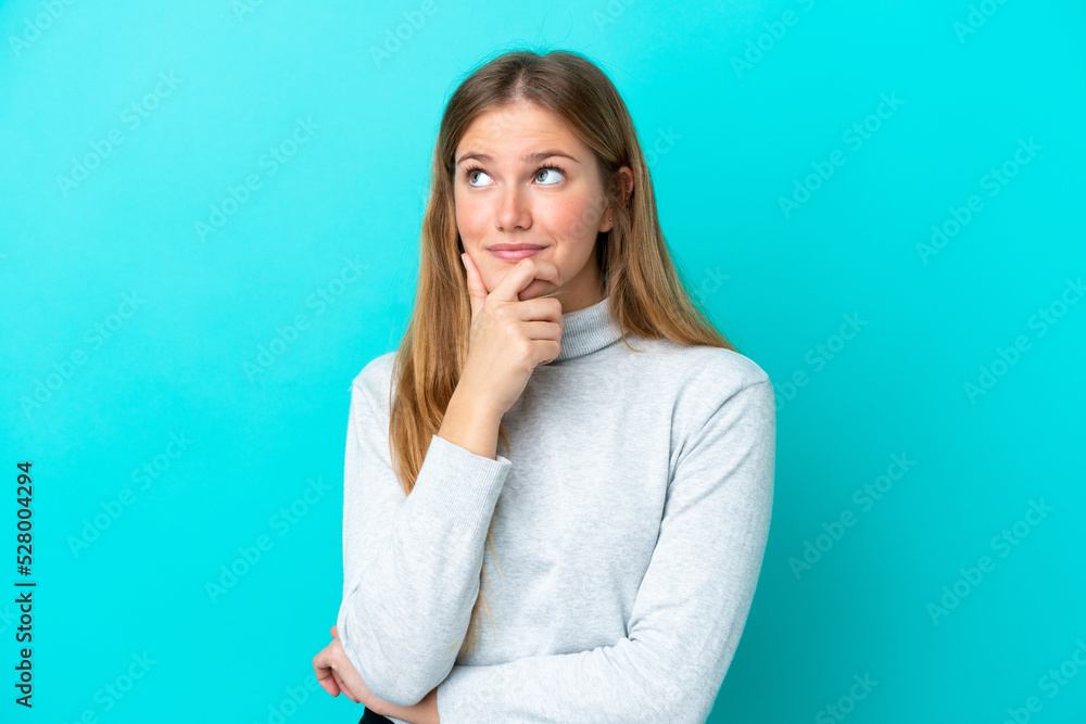 Young blonde woman isolated on blue background thinking an idea while looking up Young blonde woman isolated on blue background thinking an idea while looking up