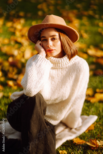 Stylish woman enjoying autumn weather outdoor. Fashion, style concept. People, lifestyle, relaxation and vacations concept.
