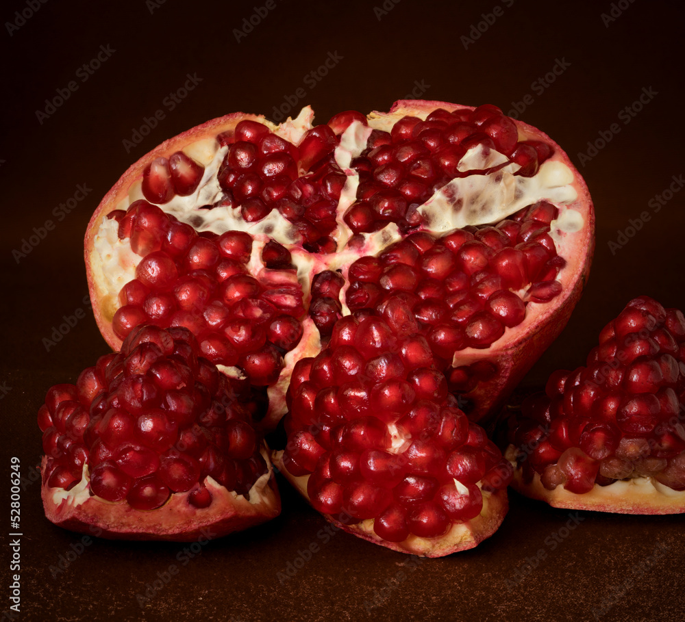 red pomegranate fruit lies on a dark background red pomegranate fruit lies on a dark background