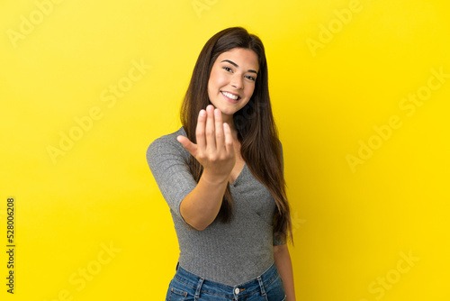 Young Brazilian woman isolated on yellow background inviting to come with hand. Happy that you came © luismolinero