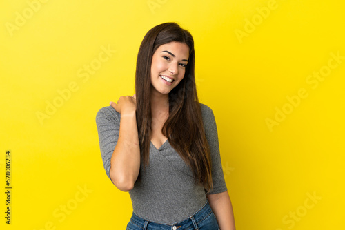 Young Brazilian woman isolated on yellow background laughing