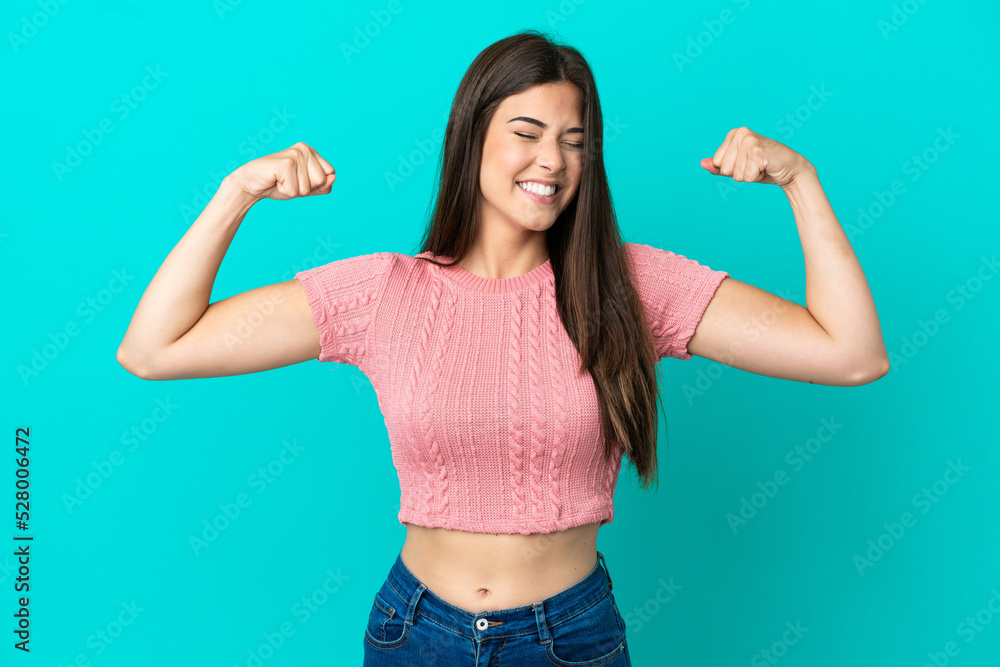 Young Brazilian woman isolated on blue background doing strong gesture Young Brazilian woman isolated on blue background doing strong gesture