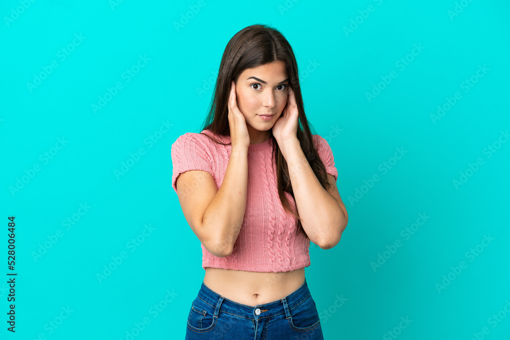 Young Brazilian woman isolated on blue background frustrated and covering ears Young Brazilian woman isolated on blue background frustrated and covering ears