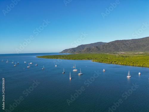 Aerial photo of Cairns marina entrance with boats, rainforrest, mountains and blue sky