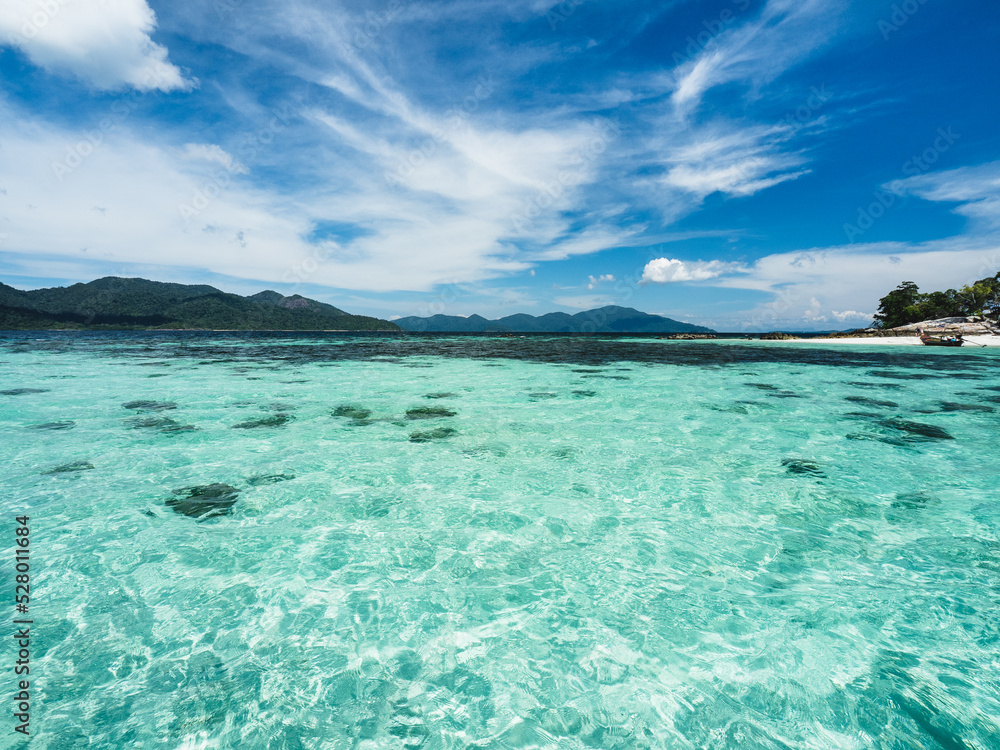 Scenic view of Koh Rokroy Island shallow crystal clear turquoise sea water with coral reef transparent against summer blue sky. Near Koh Lipe Island, Tarutao National Marine Park, Satun, Thailand. Scenic view of Koh Rokroy Island shallow crystal clear turquoise sea water with coral reef transparent against summer blue sky. Near Koh Lipe Island, Tarutao National Marine Park, Satun, Thailand.