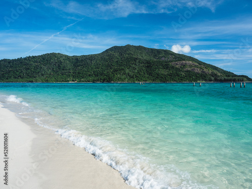 Scenic view of splashing wave of Sunrise Beach  Koh Lipe Island. White sand beach with crystal clear turquoise sea water against summer blue sky and Koh Adang Island background. Satun  Thailand.