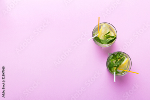 Fototapeta Naklejka Na Ścianę i Meble -  Caipirinha, Mojito cocktail, vodka or soda drink with lime, mint and straw on table background. Refreshing beverage with mint and lime in glass top view flat lay