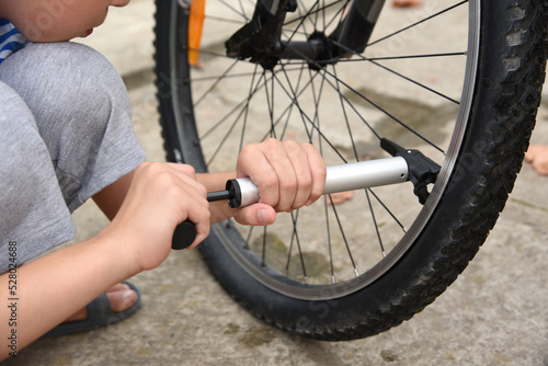 Men's Children's Hands Inflate Bicycle Wheel with Bicycle Pump Outdoors