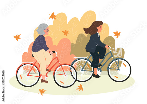 Autumn. Young and senior women on bicycles. Senior mother and adult daughter cycling together in the fall park.
