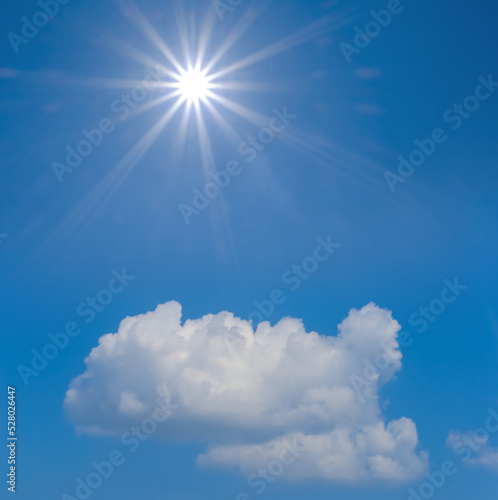 sparkle sun above dense cumulus clouds on blue sky background