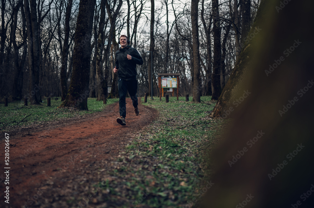 Obraz premium Young redhead man running in forest