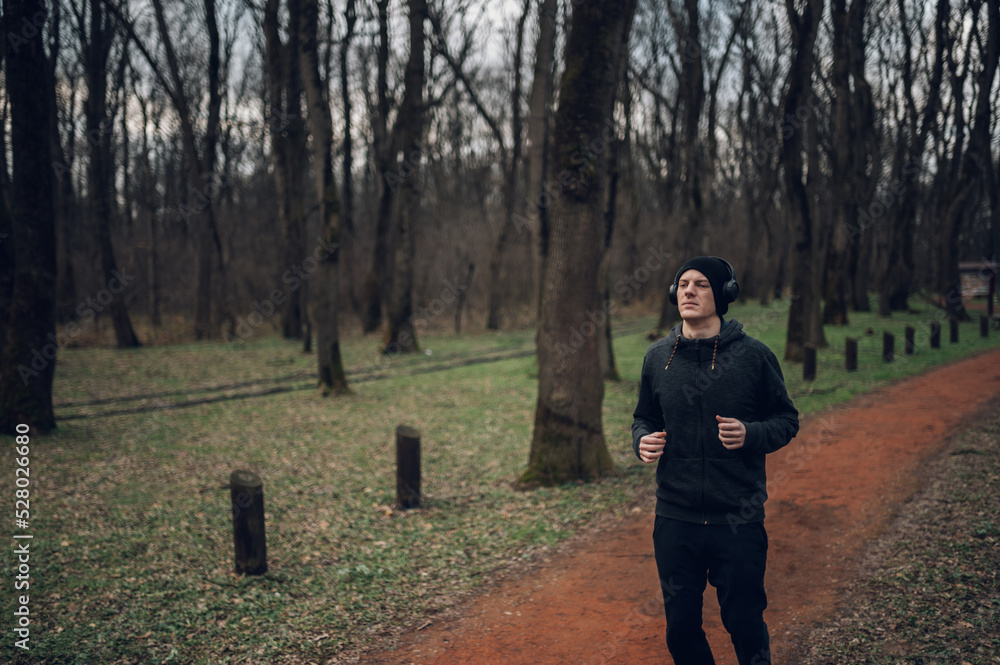 Young redhead man running in forest Young redhead man running in forest