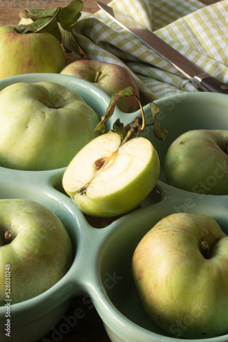 Grüne Äpfel in einer Schale mit Messer im Hintergrund