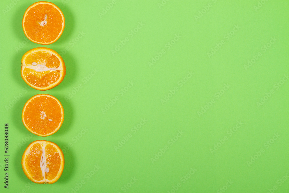 Top view of orange fruit slices on bright background in green color. Saturated citrus texture image Top view of orange fruit slices on bright background in green color. Saturated citrus texture image