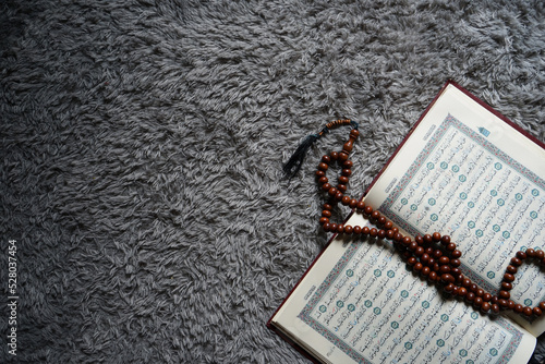 The Holy Al Quran with written Arabic calligraphy. Al Quran and rosary beads or tasbih