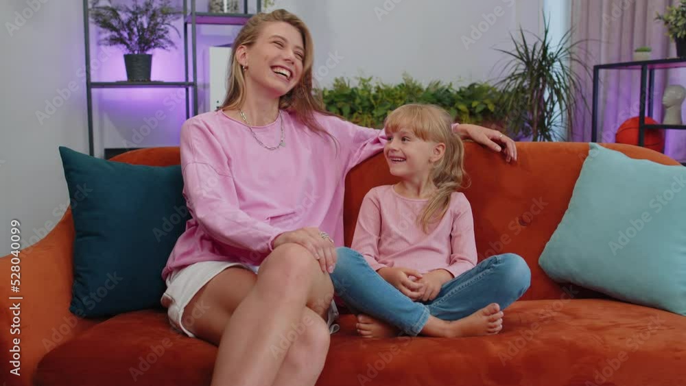 Young loving woman mom talking to little 7s daughter toddler together on couch at home. Preschool kid and mother having warm trustworthy conversation, good relation. Understanding, family bond concept Young loving woman mom talking to little 7s daughter toddler together on couch at home. Preschool kid and mother having warm trustworthy conversation, good relation. Understanding, family bond concept