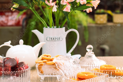 Mesa de café da manha com chá, flores e doces photo