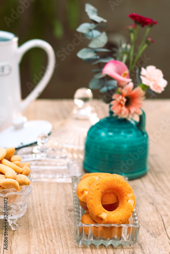 Mesa de café da manha com chá, flores e doces