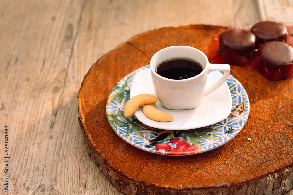 Mesa com xicara de café apoiada em pirex no suporte de madeira redondo com sequilhos Mesa com xicara de café apoiada em pirex no suporte de madeira redondo com sequilhos