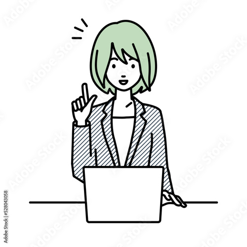 デスクで座ってPCを開いて何かひらめいたスーツの女性