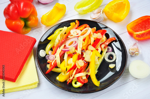 Salad of sweet bell peppers on a black plate.