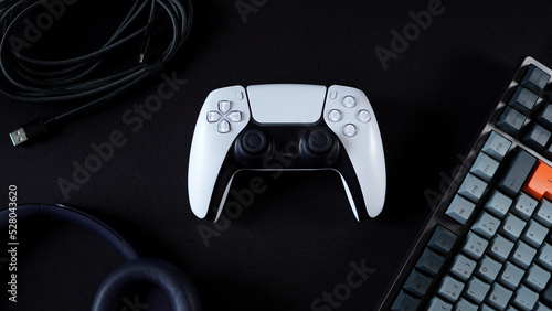 Modern gamepad surrounded by tech products photo