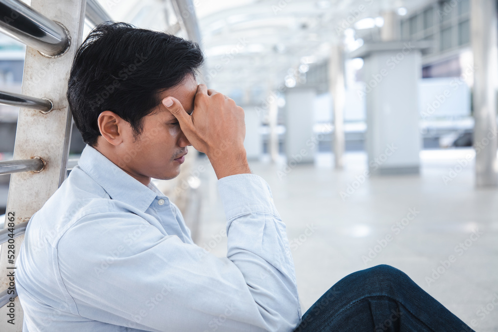 Upset young caucasian charming businessman tired from work sitting outside the office, unemployment, fired from job, disappointed mood Upset young caucasian charming businessman tired from work sitting outside the office, unemployment, fired from job, disappointed mood