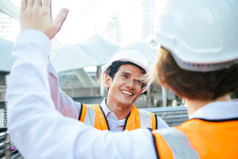 Asian business team worker engineer success on site construction near middle of cityscape, happiness and success concept. Asian business team worker engineer success on site construction near middle of cityscape, happiness and success concept.