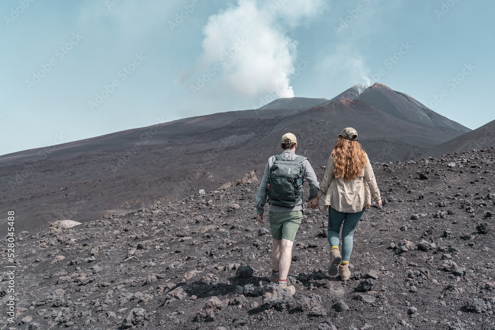 Couple hiking to a vulcanom the mount Etna.
